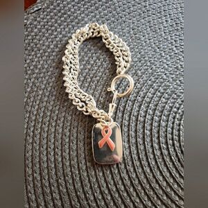 Breast cancer support stainless steel charm bracelet with pink ribbon.